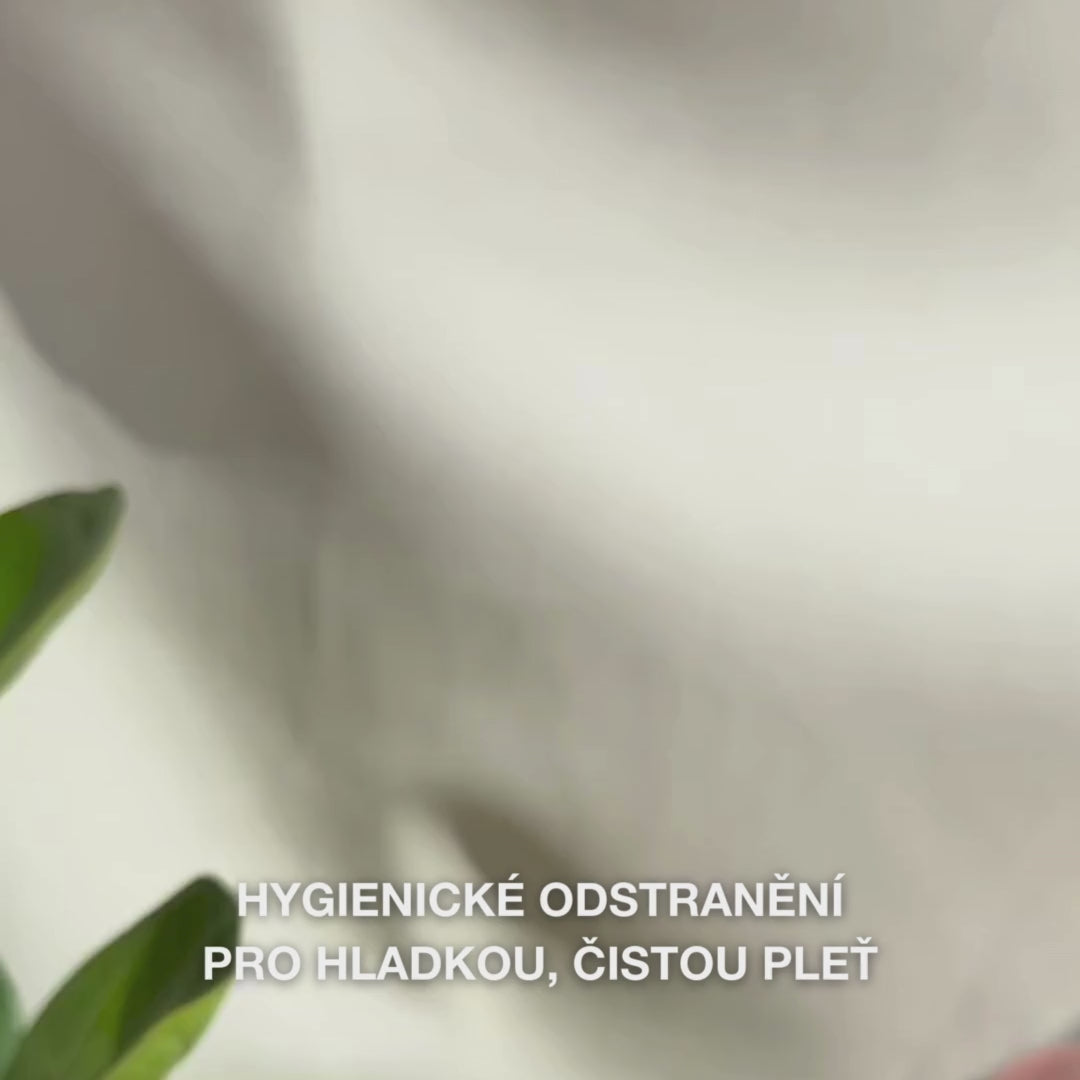 Detailní záběr rukou používajících dvoustranný nerezový nástroj na odstraňování černých teček: menší kovová smyčka jemně přitlačená kolem černé tečky na nose, následované otřením vytažených nečistot, opláchnutím nástroje a aplikací tonika a pleťového krému.