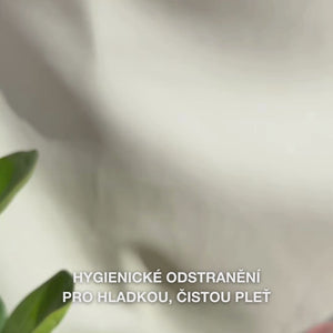 Detailní záběr rukou používajících dvoustranný nerezový nástroj na odstraňování černých teček: menší kovová smyčka jemně přitlačená kolem černé tečky na nose, následované otřením vytažených nečistot, opláchnutím nástroje a aplikací tonika a pleťového krému.