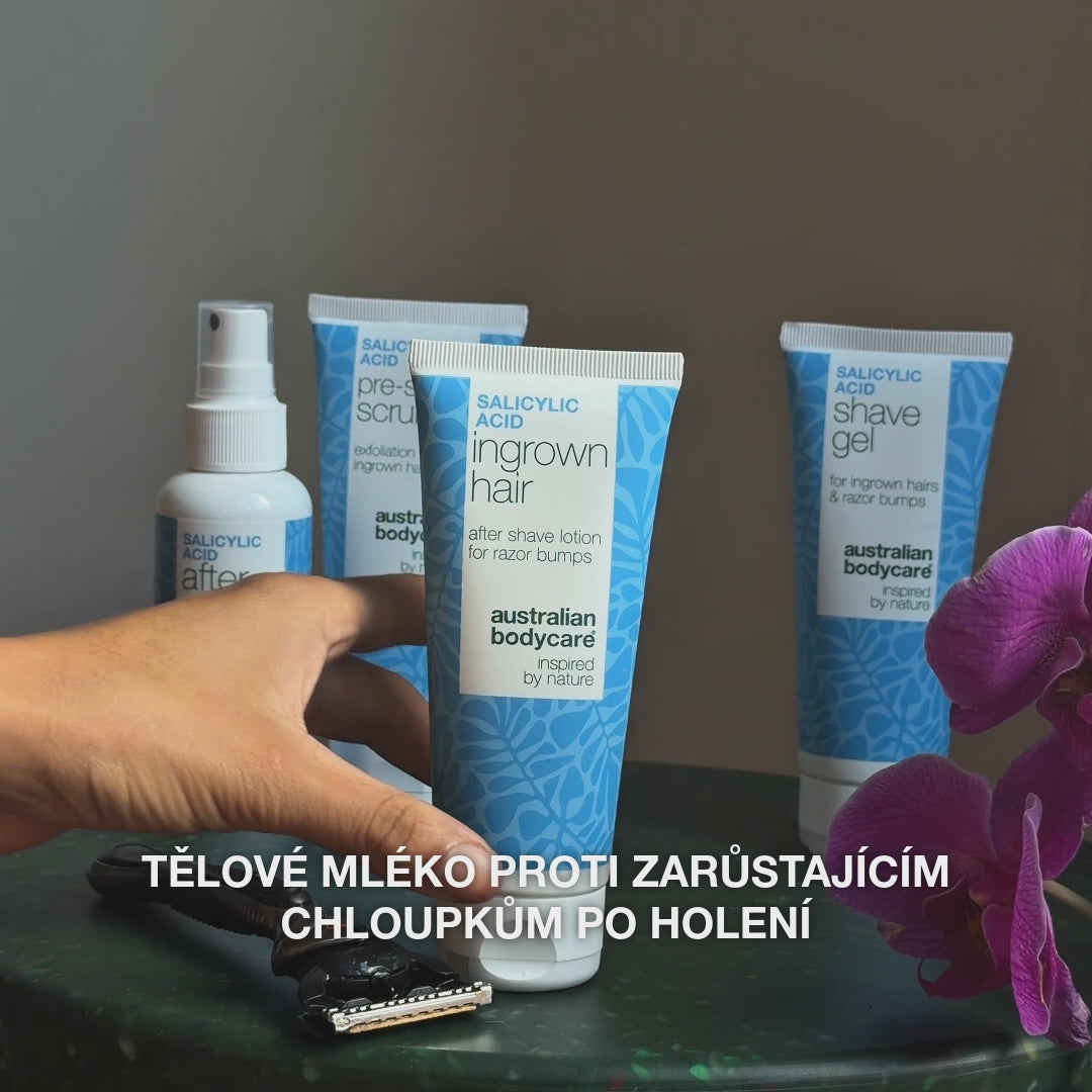 Video: sprej After Shave, Pre-shave Scrub, lotion Ingrown Hair a Shave Gel na stole vedle holicího strojku a orchideje, s textem »tělové mléko proti zarůstajícím chloupkům po holení«. Lotion po holení s kyselinou salicylovou od Australian Bodycare.