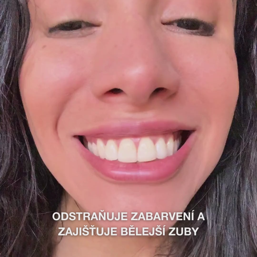 Detail ruky, která nabírá pastu Whitening Toothpaste do štětce zubního kartáčku, a jemně s ní čistí zuby krouživými pohyby: jemná textura pasty obsahuje hydratovaný oxid křemičitý (silika), aluminu a menthol, účinně odstraňuje skvrny, posiluje sklovinu a zanechává svěží dech 