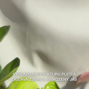 Detail ruky, která nanáší několik tenkých kapek čirého, lehkého Peeling Serumu na konečky prstů a jemně ho vmasíruje do čisté pleti — jeho hedvábná, tekutá textura patrně odstraňuje povadlé povrchové buňky, vyhlazuje strukturu pleti a rozjasňuje díky přírodním AHA (Lime Pearl), niacinamidu a tea tree oleji 