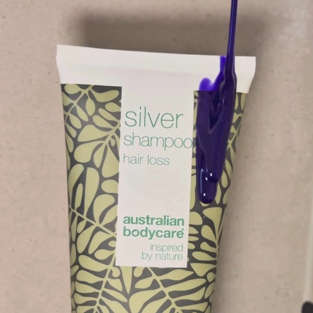 Video ukazující náš Hair Loss Silver Shampoo se stříbrno-fialovým odstínem nanášený na mokré vlasy ve sprše.